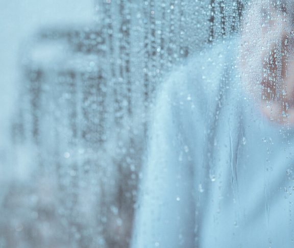 dreng med depression kigger på regnen