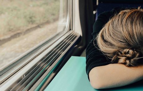 kvinde med Narkolepsi ligger over bordet i toget