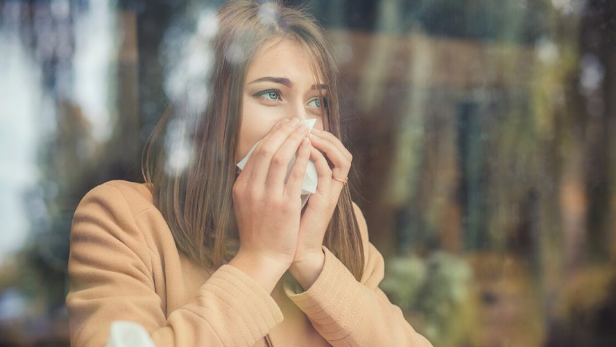 kvinde med allergi eller astma pudser næse