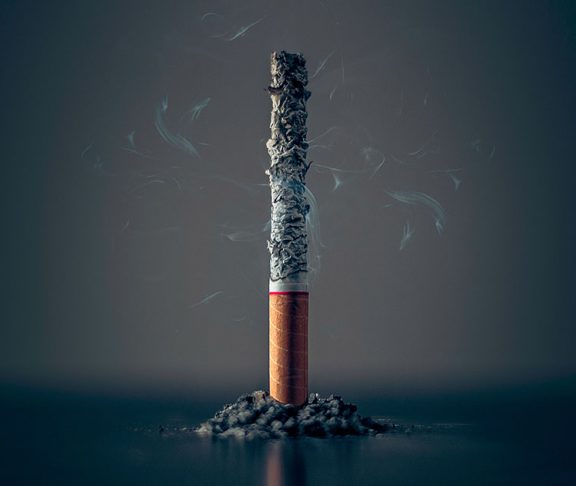 Udbrændt cigaret står vertikalt på bord