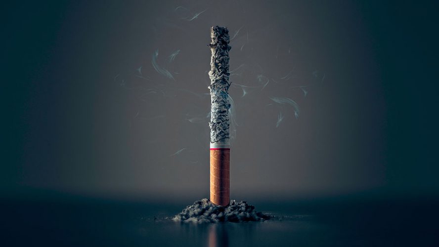 Udbrændt cigaret står vertikalt på bord