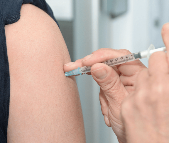 læge giver influenzavaccine til patient