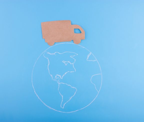 Paper cut of truck on the earth. delivery concept