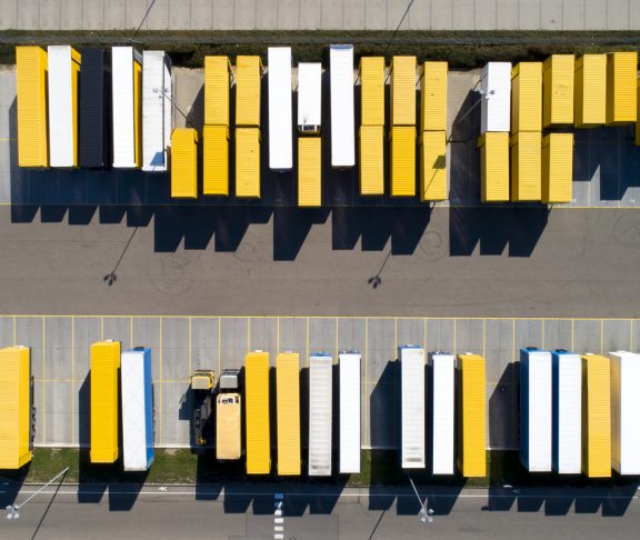 Aerial view of cargo containers, semi trailers, industrial warehouse, storage building and loading docks, Bavaria, Germany