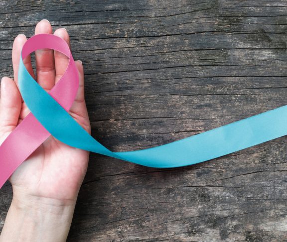 Pink blue ribbon awareness (isolated with clipping path) bow color for newborn birth defect, Sudden Infant Death Syndrome (SIDS), pregnancy Loss on helping hand