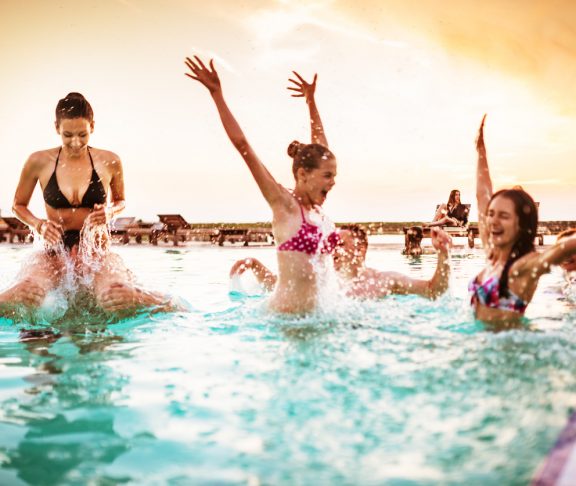 group of young adult girl having fun on swimming pool