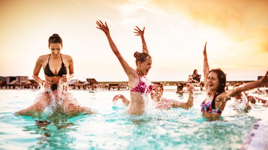 group of young adult girl having fun on swimming pool