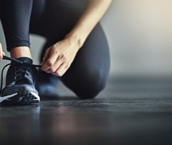 Cropped shot of a woman tying her shoelaces before a workout