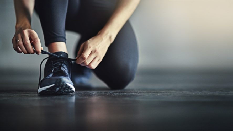 Cropped shot of a woman tying her shoelaces before a workout