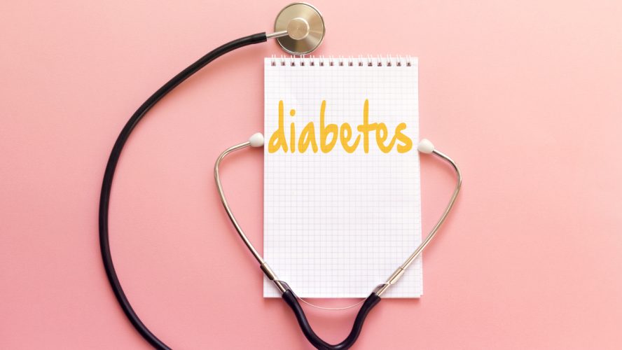 disease diabetes concept handwriting on white notebook and stethoscope on pink background