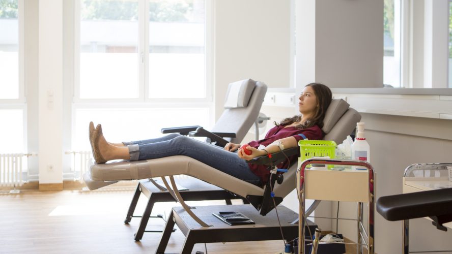 young woman lay on back while she is donating blood