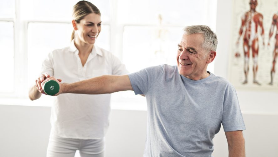 Modern rehabilitation physiotherapy worker with senior client