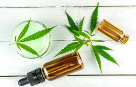 CBD Cannabis Hemp topical cream and oils balm with cannabis leafs on wooden table