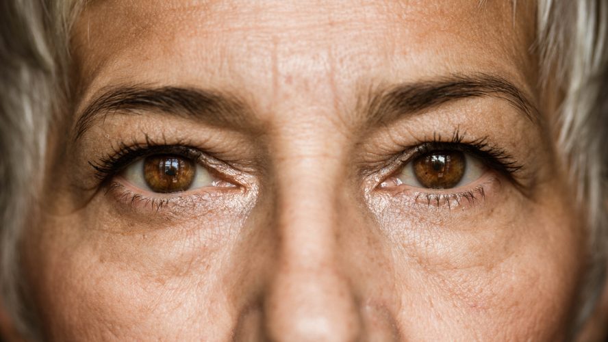 Close up of senior woman's brown eyes looking at camera.