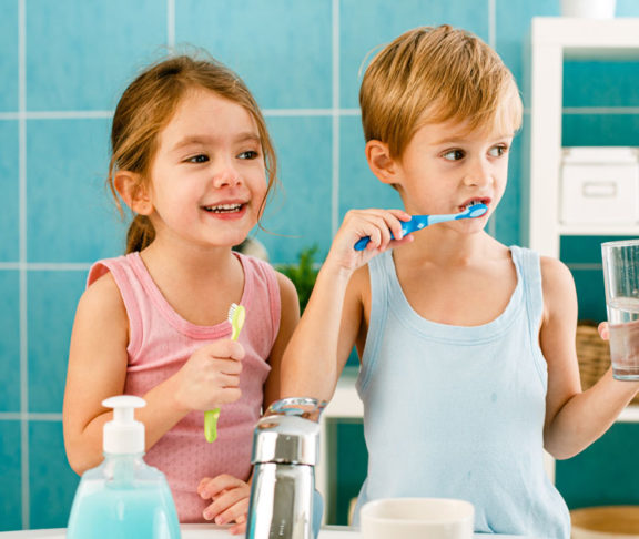 Sibling brushing their teeth in the bathroom together