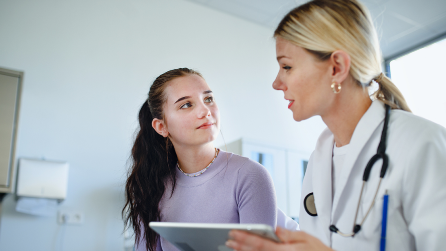 Young woman doctor explaining diagnosis to teenage girl