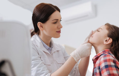Attentive ENT doctor doing nose exam of her daughter