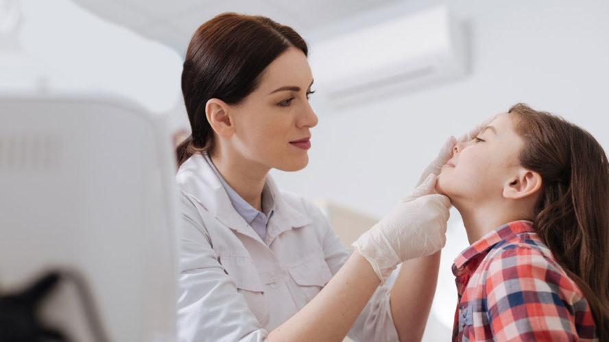 Attentive ENT doctor doing nose exam of her daughter