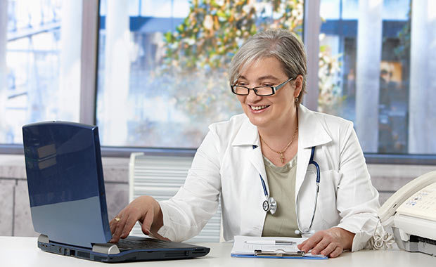 Vrouw in doktersjas met laptop