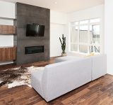 Stijlvol ingerichte woonkamer met bank, kast flatscreen-tv en houten vloer
