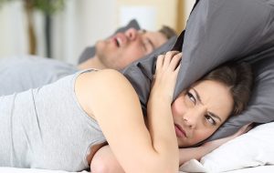 Jonge vrouw heeft last van het gesnurk van haar partner.