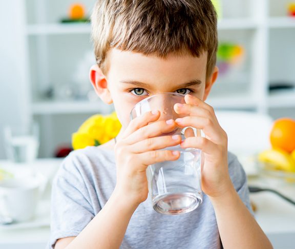 Kleine jongen drinkt glas met water