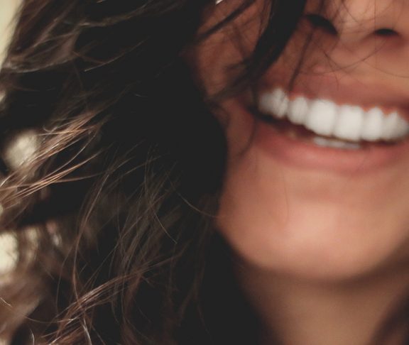 Close-upfoto van lachende jonge vrouw