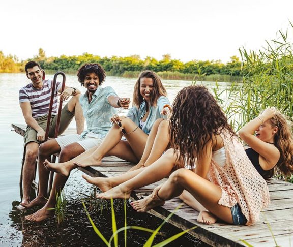 Lachende groep mensen bij het water