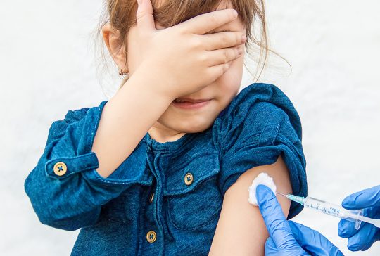 Jong meisje krijgt vaccin toegediend.