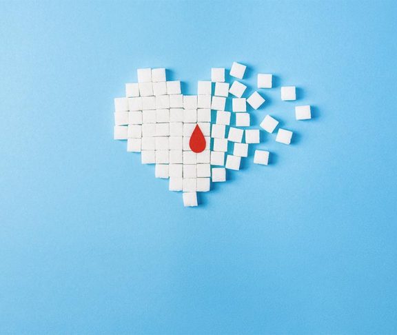 Suikerklontjes geordend in vorm van een hart met bloeddruppel.