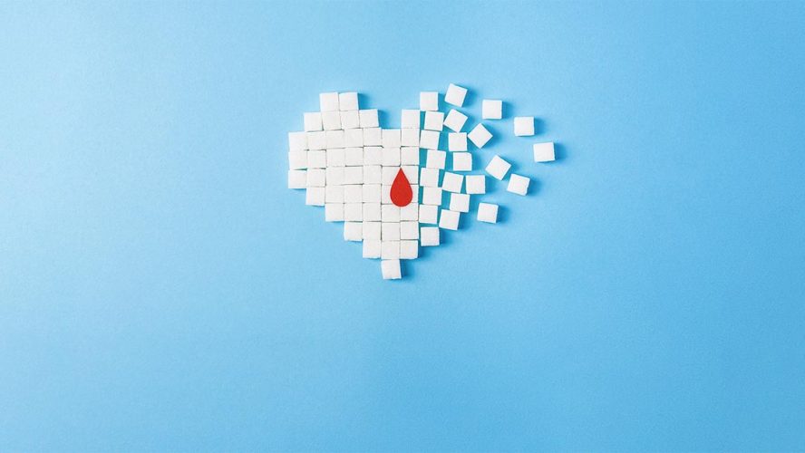 Suikerklontjes geordend in vorm van een hart met bloeddruppel.