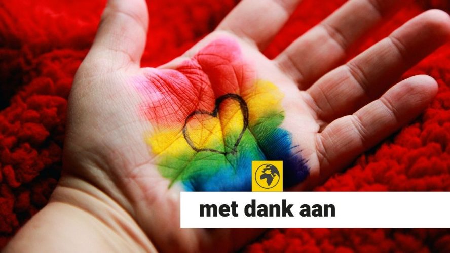 Hand met regenboogvlag en hartje in de palm geschilderd